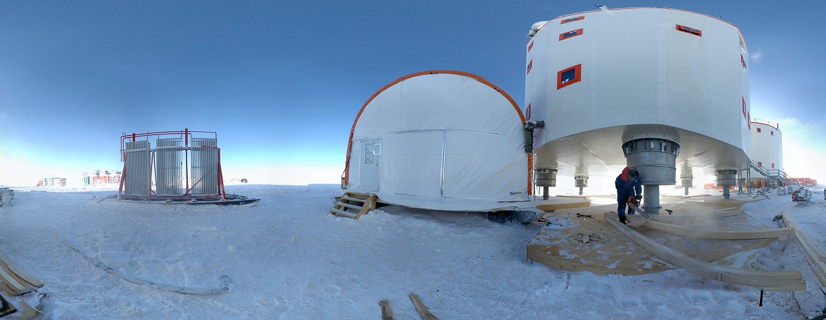 [PanoCutWood.jpg]
Michel cutting wood with a chainsaw right below Concordia, next to the garage, where the wind chill is the fiercest because of the Venturi effect. The radiator of the summer camp power plant lays on the left before the food and garbage containers.