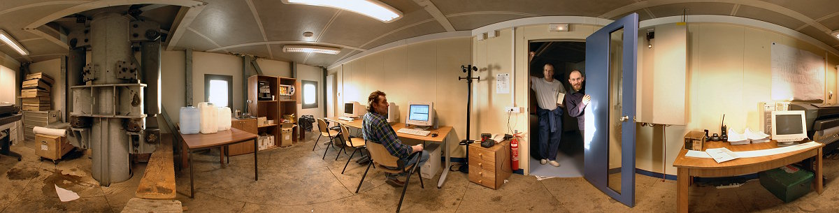 [PanoEmailRoom.jpg]
Not yet paved, the email and computer room also acts as storage and coffee room. One of the large hydraulic foot of the station is clearly visible in the center of the room. With Michel at the keyboard, Roberto with his medical bible in hand and Emanuele coming for a closer look.