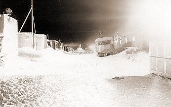 [ANT17.jpg]
McMurdo Sound (U.S. Navy Station). Middle of Winter in the base camp. Parked in the street is an amphibious army version of the Weasel.