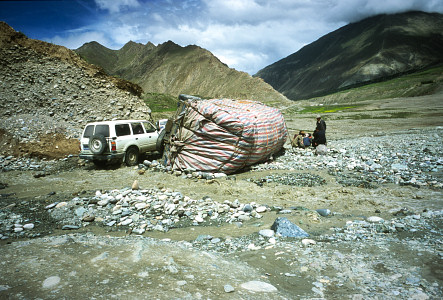[Overturned.jpg]
After this little touristic trip in Tibet, it took us 3 days to do only 400km to reach the Drive Camp of Cho-Oyu, our true destination. The road was very muddy thanks to the end of the monsoon and many rock slides had carried away parts of the road as this truck can testify. In those parts they seem to mark the side of the road with broken trucks...