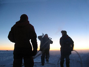 Claire, Michel and Christophe carrying fuel tubes outside