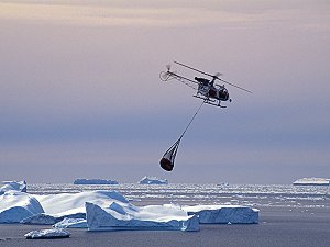 Helicopter carrying loads above icebergs