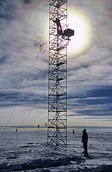 AmericanMastAssemblyBacklit2 - Setting up an instrument on a mast, with irridescent clouds in the background.