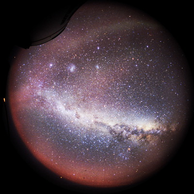 [MilkyWayFV_.jpg]
A 180° shot of the Milky Way across the Antarctic sky. Part of the telescope is visible on the upper left of the image and the band next to it is a faint aurora. The two white blurs are the Magellanic clouds. The dark area on the Milky way is called the Coal Sack and is a typical southern hemisphere feature, quite visible to the naked eye. The reddish lower part is light from the sun, still way bellow the horizon but shining nonetheless. More info about fisheye photography.