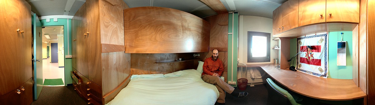 [PanoBedroom.jpg]
View from the inside of one of the cleanest bedrooms: Emanuele's. The bunk bed folds up in winter as we are 13 for 18 bedrooms (there's also the doctor's bedroom and the engineer's bedroom located on the 1st floor). All the furniture is custom design to fit the 200° angle between the walls (360° divided by 16 bedrooms plus two empty ones used for storage).