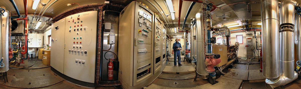 [PanoPowerPlant.jpg]
Most important element of the station, the power plant and its three generators supervised by Christophe. The generators themselves are the yellow devices visible behind their large vertical metallic exhaust pipes. The door to the workshop is right behind him. The power plant was initially planned to be in the noisy building where the backup generator is, but then lack of space and fire hazard made it so that an extra set of large containers was added next to the station.