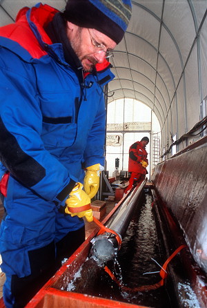 [DrillKerosenBath2.jpg]
Removing the drill from the kerosene bath after it's warmed up enough. The ice core, visible inside, should now be removable.