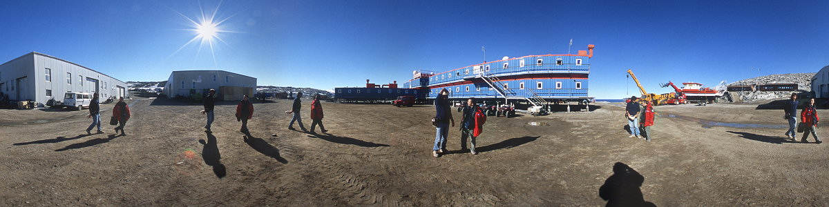 [BTNplaceAPano_.jpg]
Panoramic view of the station (and two (12?) clowns) taken from the center of the station. From left to right: Garage and workshop, storage building, main life building, grounded boat, wooden sleeping sheds.