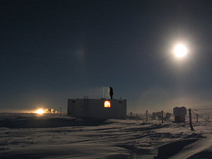 Jeff on the roof of the Atmos shelter, with the green laser of the Lidar visible and Concordia in the background