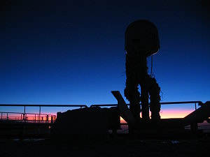 Colorful glow on the northern horizon on a midwinter mid-day, with the satellite antenna in foreground