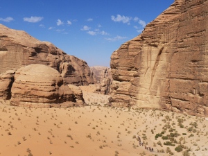 Bedouins and tourists on dromedaries passing through Barrah canyon