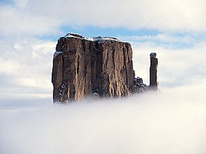 Sandstone tower piercing the clouds at Monument Valley