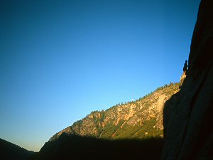 Sunset and moonrise as seen from Heart Ledges, with a climber fixing the 1st pitch of the Salathé Wall. El Capitan