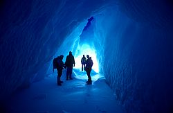 IceCavePeople - Explorers in an ice cave within an iceberg, Antarctica