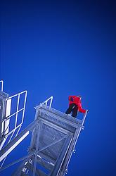 StairsUnused1 - Red man on unused staircase with deep blue sky.